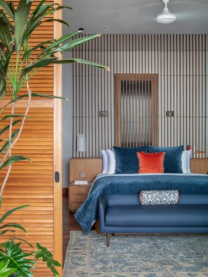 The master bedroom is defined by a wooden screen and console that create a passage to the walk-in wardrobe and bathroom. This element also anchors the bed, which is oriented to take in the sweeping views of the Arabian Sea.