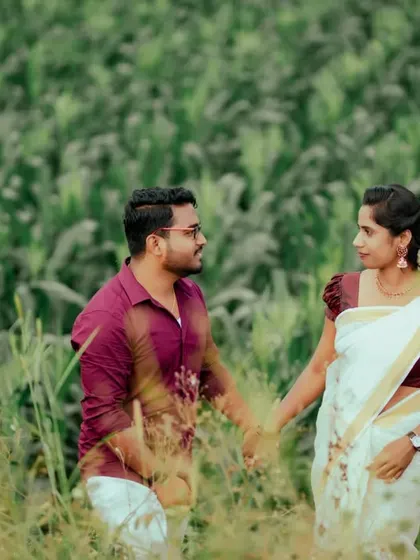 A couple holds hands while walking through a field, a simple and timeless expression of their connection during a pre-wedding shoot.
