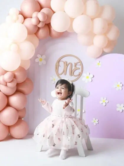 Pure excitement! This little princess is all smiles, celebrating her first birthday with a gorgeous pastel balloon setup.