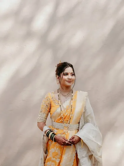 A full view of the stunning yellow and white Nauvari, showing the elegant drape and the beautiful contrast of the champagne-colored shela (shawl).