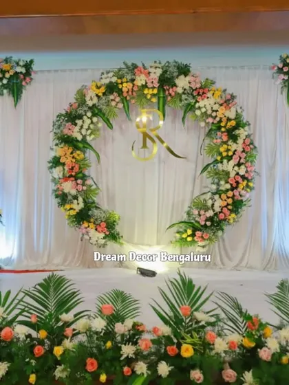 A full view of the elegant engagement stage with a large floral wreath as the centerpiece.