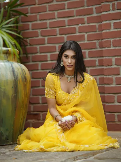 A close-up portrait in the yellow saree, showing its flattering color and design.