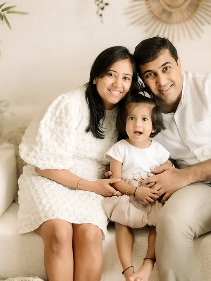 A classic family portrait on the studio couch. The neutral tones and simple setting really let the family's connection shine.