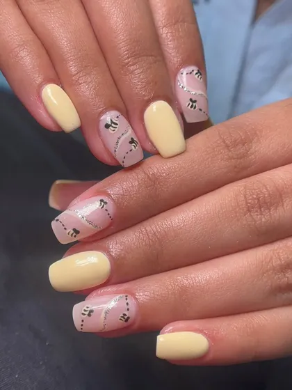 This honeybee-inspired nail art is so cute and chic. I used a pale yellow polish and created a negative space design with silver glitter trails and tiny, hand-painted bees.