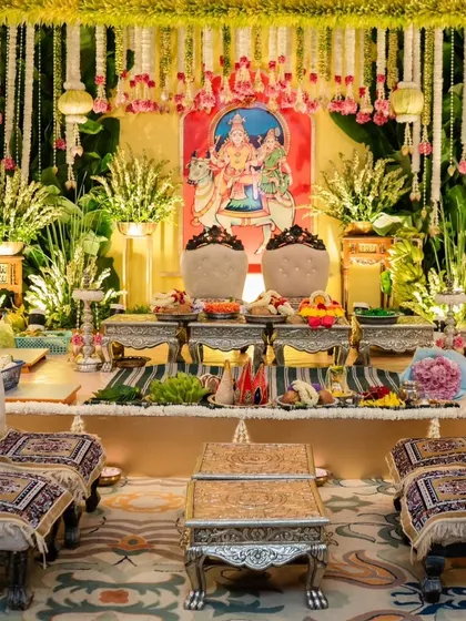 A full view of a traditional Muhurtham stage. The setup includes ornate seating for the family, a floral backdrop, and a variety of offerings, all meticulously arranged to honor the sanctity of the ceremony.