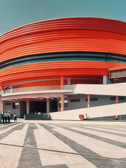 The bold, ribbed texture of the MARC Auditorium's facade creates a tactile quality and a play of light and shadow across its curved surface.