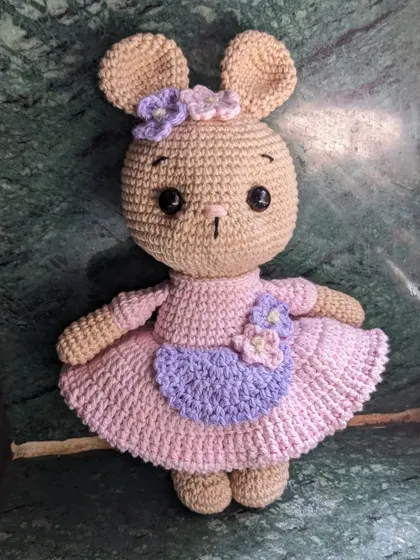 The bunny doll standing against a dark green marble background.