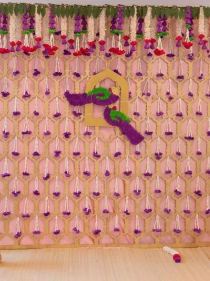 A unique backdrop with a gold lattice frame and hanging floral elements. The little bird motifs made of flowers add a playful and charming detail to the design.