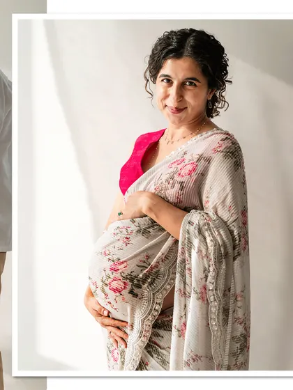 A beautiful portrait of a smiling mom-to-be in a floral saree, showcasing a unique and elegant maternity style.