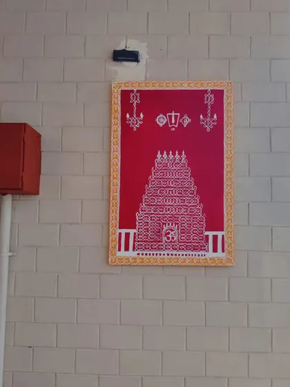 This custom art piece features a detailed representation of a temple gopuram, bringing a sacred and traditional element to the home's exterior wall.