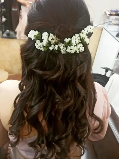 My bridal packages include professional hairstyling. Here, my hairstylist created a lovely half-up style with soft curls, adorned with fresh baby's breath for a romantic and delicate touch.
