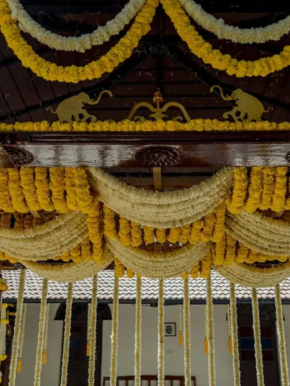 A close-up of the Haldi mandap roof, adorned with yellow and white garlands.