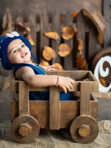 This little one is all smiles, sitting in a wooden cart as part of our rustic first birthday theme.