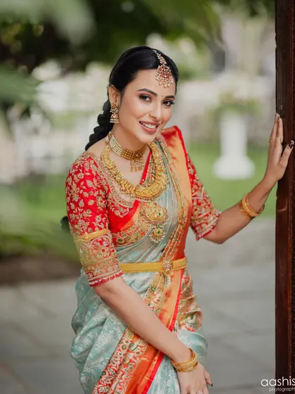 A classic pose by the doorway, showcasing the elegant drape of her saree and the flawless makeup.