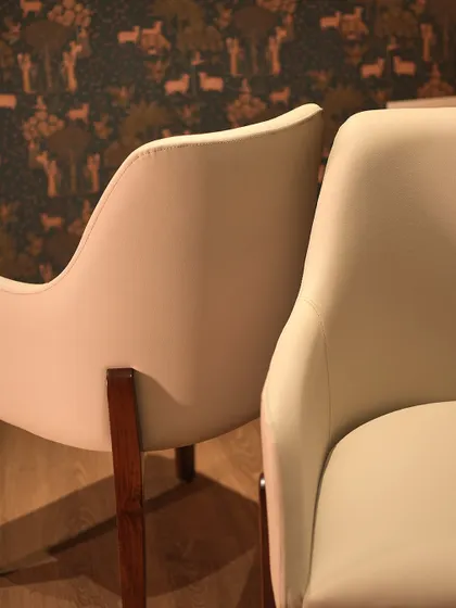 A detail shot showing the smooth, curved back of the upholstered armchair, highlighting the quality of the fabric and the seamless construction.