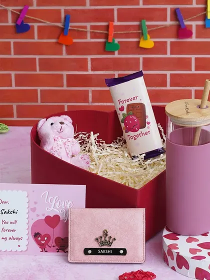 The "Love Keepsake Hamper" for her, featuring a personalized pink glass tumbler, a matching pink mini wallet, a teddy, chocolate, and a custom message card in a heart-shaped box.