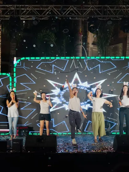 A team performs on a stage with a custom LED backdrop featuring geometric patterns. We design these backdrops to be immersive and align with the event's theme or branding.
