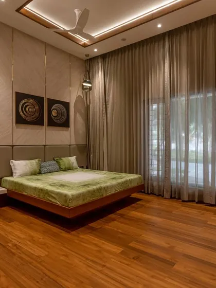 A serene bedroom with a floating platform bed, soft accent lighting, and full-length sheer curtains that diffuse the natural light, creating a calm and restful environment.