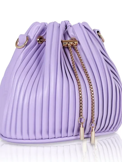 A three-quarter view of a lavender pleated bucket bag, highlighting its unique shape and gold chain details.