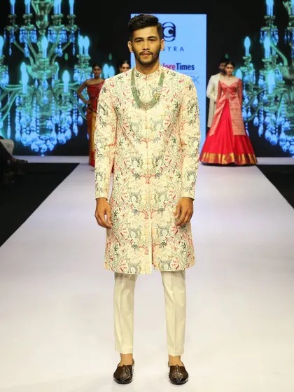 A direct, full-length shot of the runway sherwani. The straight, clean cut of the garment combined with its elaborate surface embroidery makes it a perfect choice for a modern groom who appreciates fine detail.