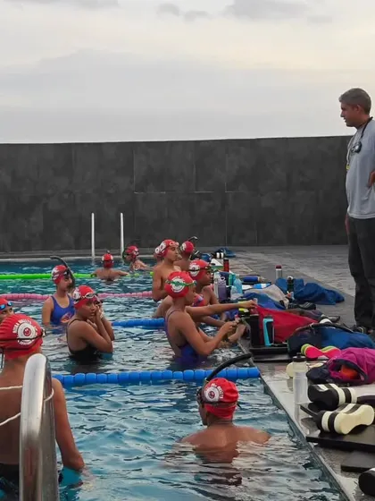 A coach briefs the team, all sporting their new red caps. It's great to see everyone looking like a cohesive unit.