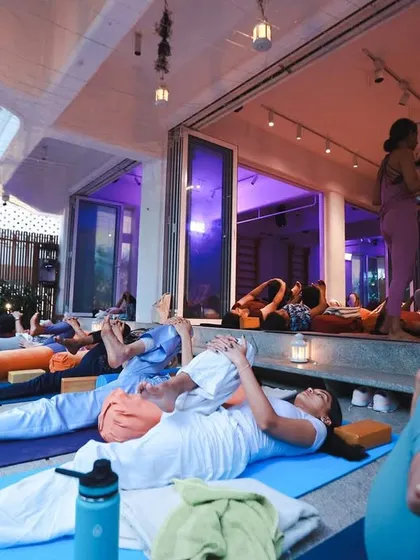 A beautiful moment of collective rest during a yoga day celebration. The indoor and outdoor spaces merge, allowing students to feel both connected to the group and to the nature outside.