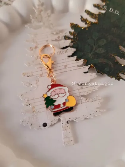 A close-up of the Santa charm on a paper Christmas tree, showing its cute and jolly design.