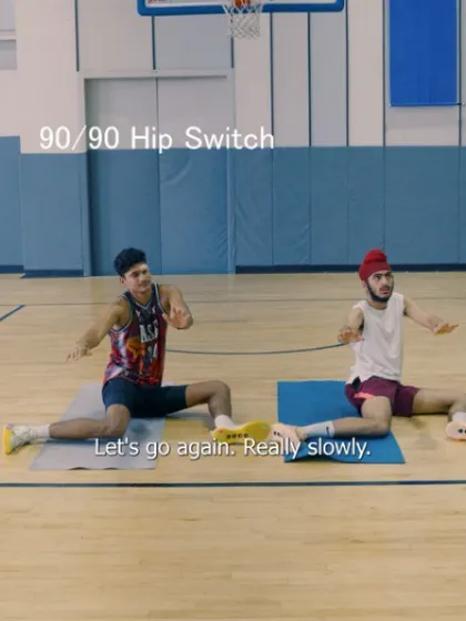 An image showing two athletes performing the 90/90 hip switch, a fundamental drill for dynamic hip mobility.
