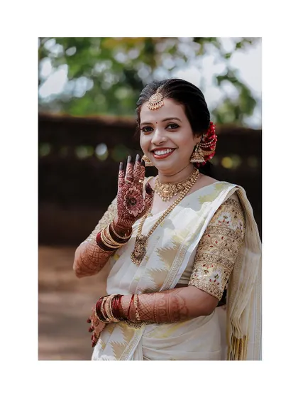 A welcoming gesture from the bride, her hand raised in a traditional greeting.