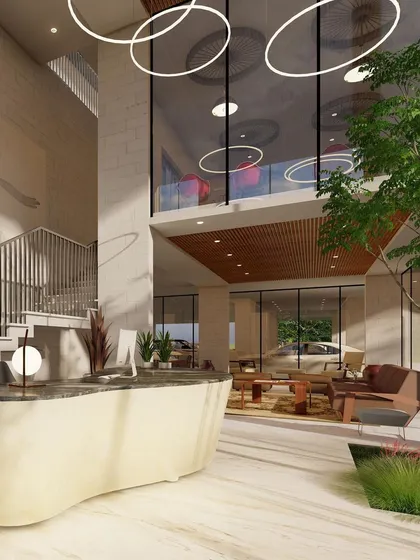 The reception lobby design for Nandi Souls. An organic-shaped desk and circular pendant lights soften the space, while indoor trees reinforce the project's goal of connecting residents with nature.