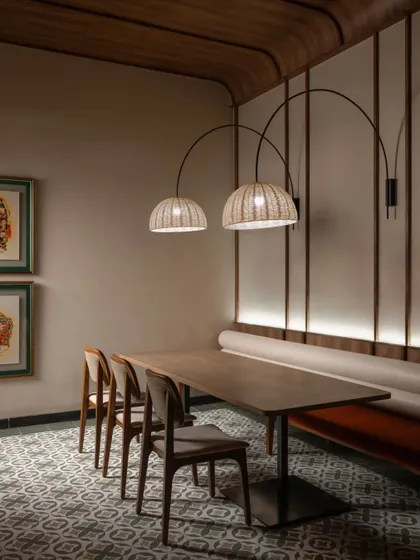 A view of the long bench seating with arched lamps overhead. This setup is ideal for larger groups and demonstrates our approach to flexible and functional hospitality seating solutions.