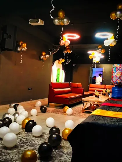 Another angle of the party lounge, showing balloons scattered on the floor and hanging from the ceiling, ready for a night of celebration.