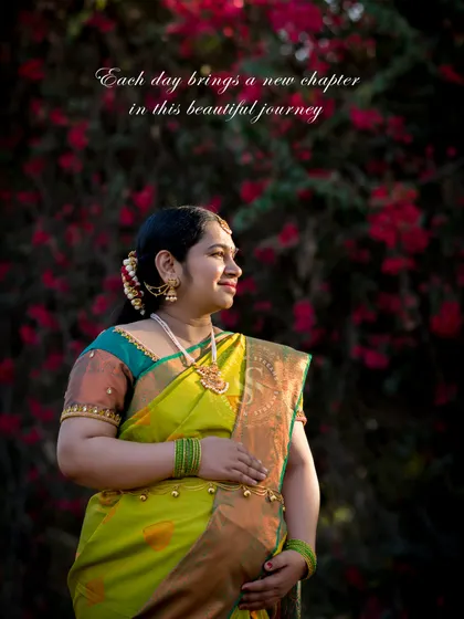 A thoughtful portrait of a mom-to-be in a traditional yellow saree, looking towards her future. The floral background adds a touch of romance.