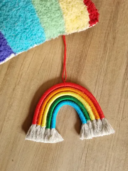A simple and colorful macrame rainbow car hanging. This piece is a cheerful reminder of creativity and joy, perfect for brightening up your car's interior.
