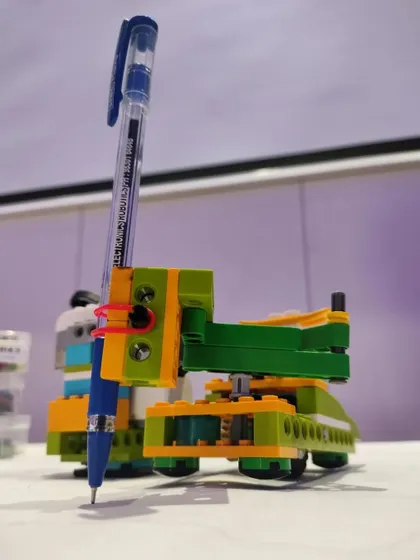 A detailed look at a drawing robot, designed to hold a pen and create art based on its programmed instructions.