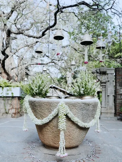 A large stone urli decorated with a simple jasmine garland, showcasing understated elegance.