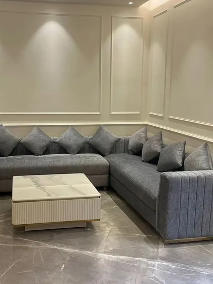 A direct view of the grey sectional sofa, showcasing its generous proportions and plush cushions. We design our sectionals to be the heart of the living room, perfect for family gatherings and relaxation.