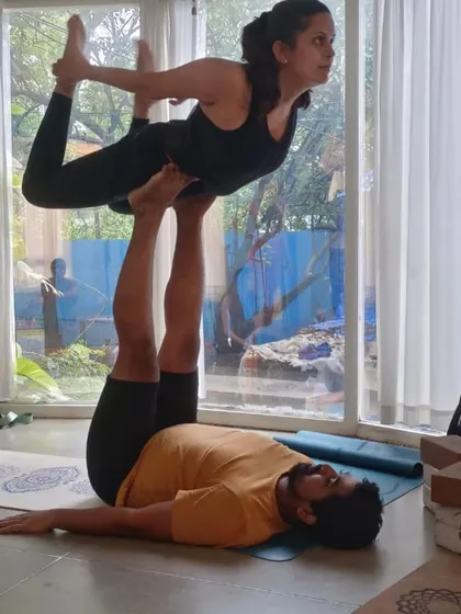An Acro Yoga backbend pose, 'Bow on Throne'. This is a beautiful partner stretch that helps open the flyer's heart and spine with the support of the base.