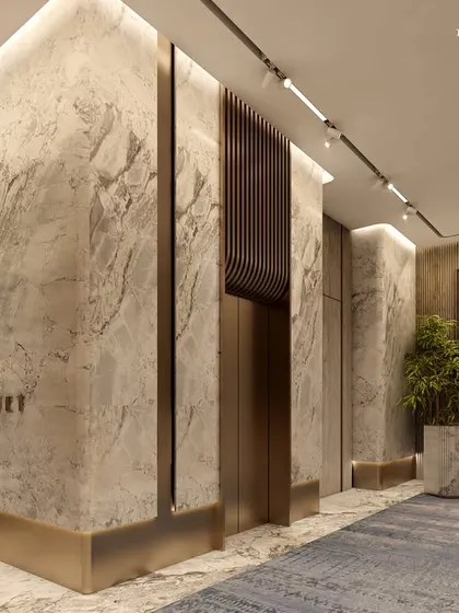 The corridor leading to the banquet hall at Ceejay Residency. The walls are clad in dramatic marble with brass inlays, setting a tone of opulence and elegance for the exclusive clubhouse experience.
