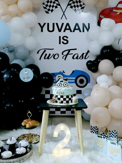 This "Two Fast" race car themed party setup shows how my cake can be the centerpiece of your event decor. The custom cake is displayed alongside matching cupcakes and party decorations for a cohesive look.