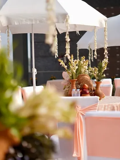A closer, artistic shot of the dining setup, focusing on the hanging jasmine and the soft color palette.