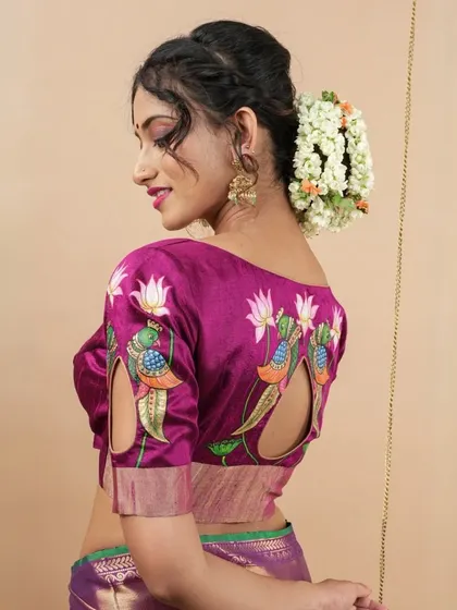 A side view of our magenta blouse, showing the intricate hand-painted details that extend from the back to the sleeves.