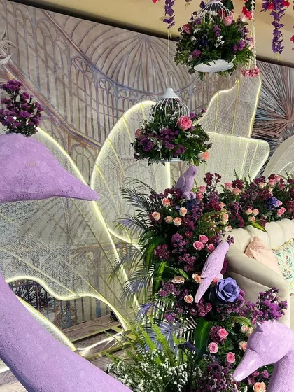 Sculptural swan props and hanging birdcages filled with flowers add a whimsical touch to our illuminated garden theme.