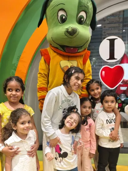 A group of adorable friends huddle together with our mascot for a memorable photo. We love seeing these happy smiles.
