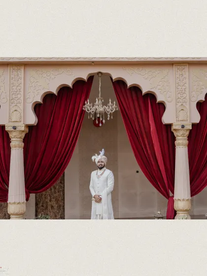 A wide shot of the groom waiting under a grand archway, creating a sense of anticipation.