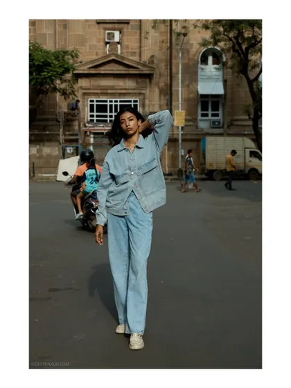 A casual denim-on-denim look captured on the streets of Mumbai. The image has a relaxed, documentary feel, as if capturing a real moment in time.