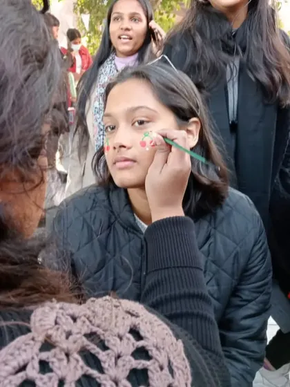 In the middle of painting cute cherries on a client's cheeks at a college fest. The fun is in the creation.