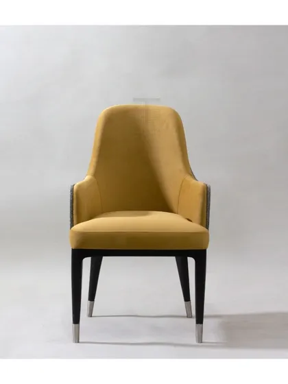 This dual-fabric dining chair combines a mustard yellow velvet with a textured grey fabric on the back. The sleek black legs are tipped with metal, adding a touch of modern elegance.