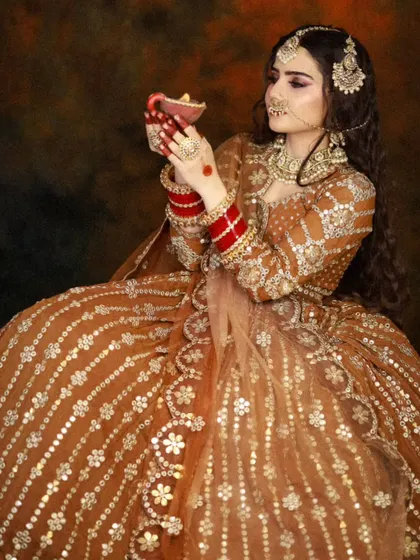 A seated portrait that highlights the flow of the lehenga and the elegance of the pose.