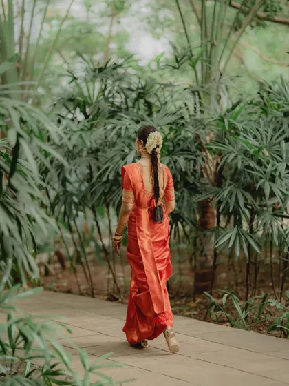 A full back view of a traditional South Indian braid, showcasing its length and the beautiful floral and gold accessories woven into it.